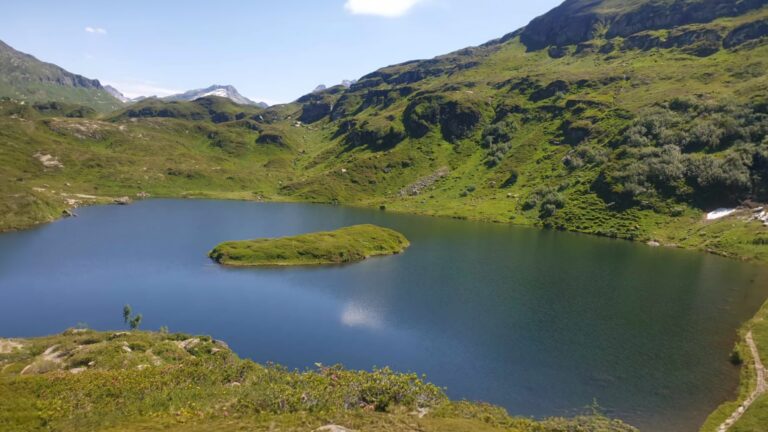 Le lac de Pormenaz et son petit îlot au milieu des alpages