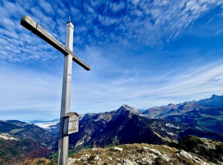 Croix en bois au sommet du Suet face aux montagnes des Aravis