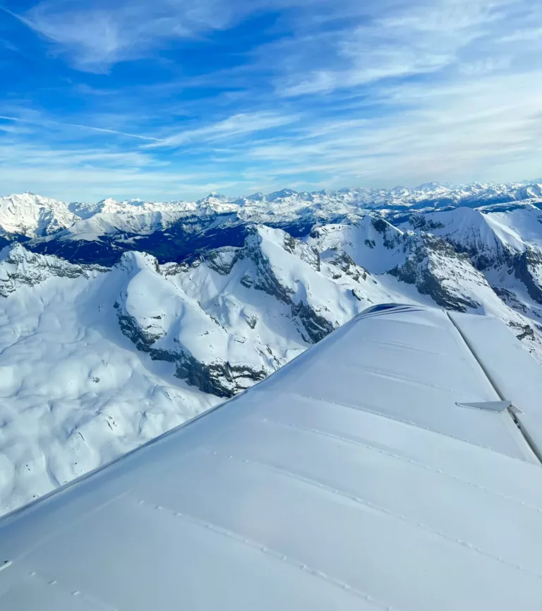 Les Alpes enneigées vues depuis l’aile de l’avion, lors d’un baptême de l’air au départ d’Annecy
