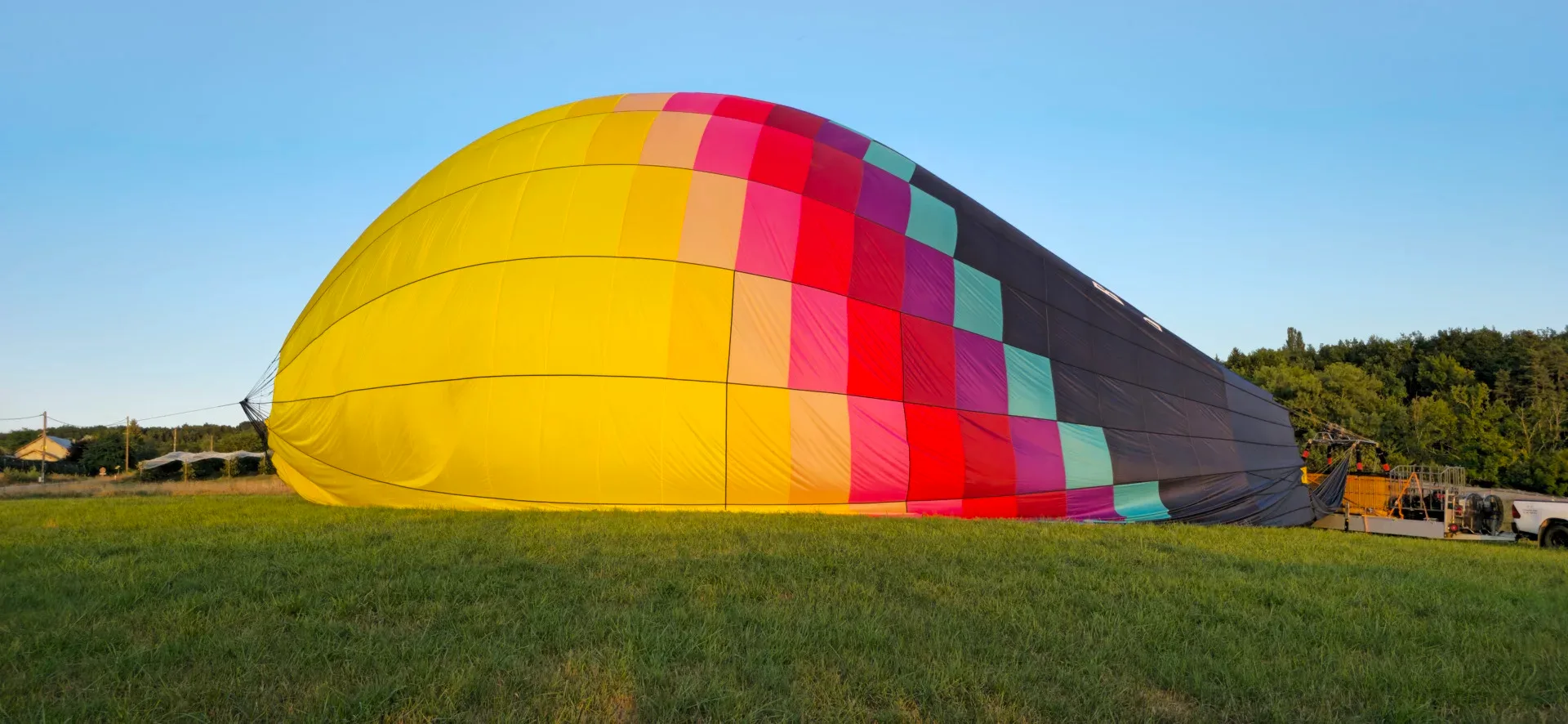 Gonflage d’une montgolfière colorée au sol avant le vol, en Haute-Savoie